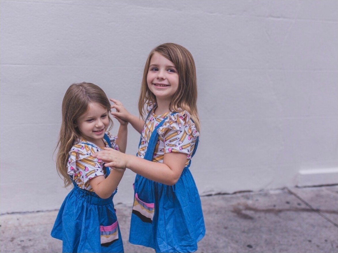 The Harvey girls smiling in matching pencil-print outfits