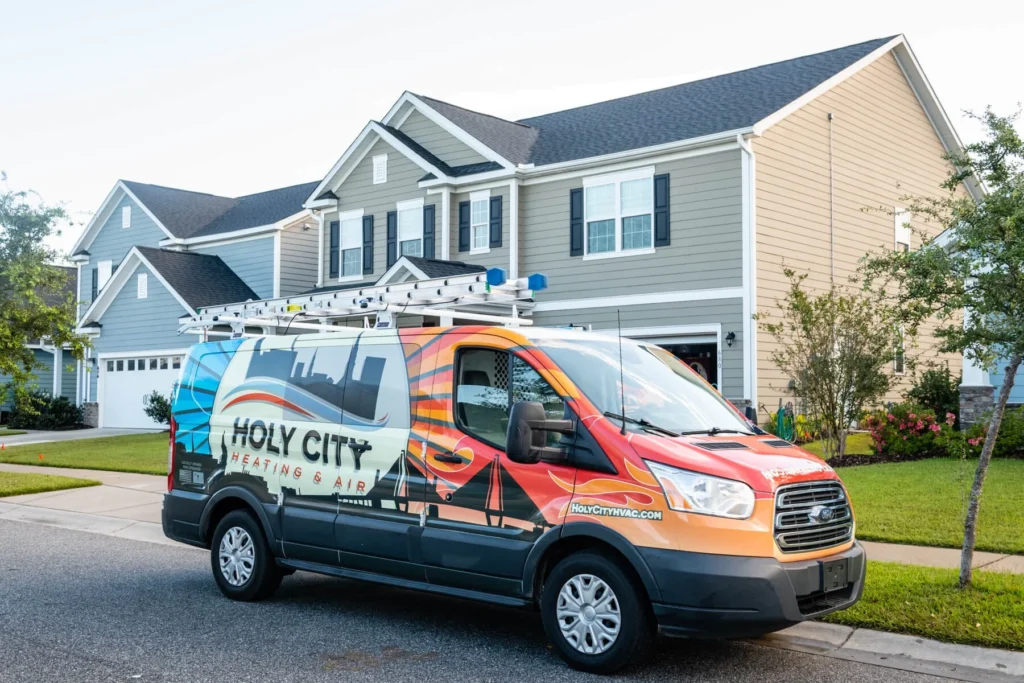 A wrapped Holy City Heating & Air van parked in front of a Lowcountry home